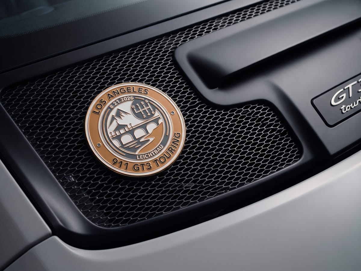 Mockup of the Leichtbau crest as a round enamel badge on the engine grille of a grey 911 GT3 Touring.